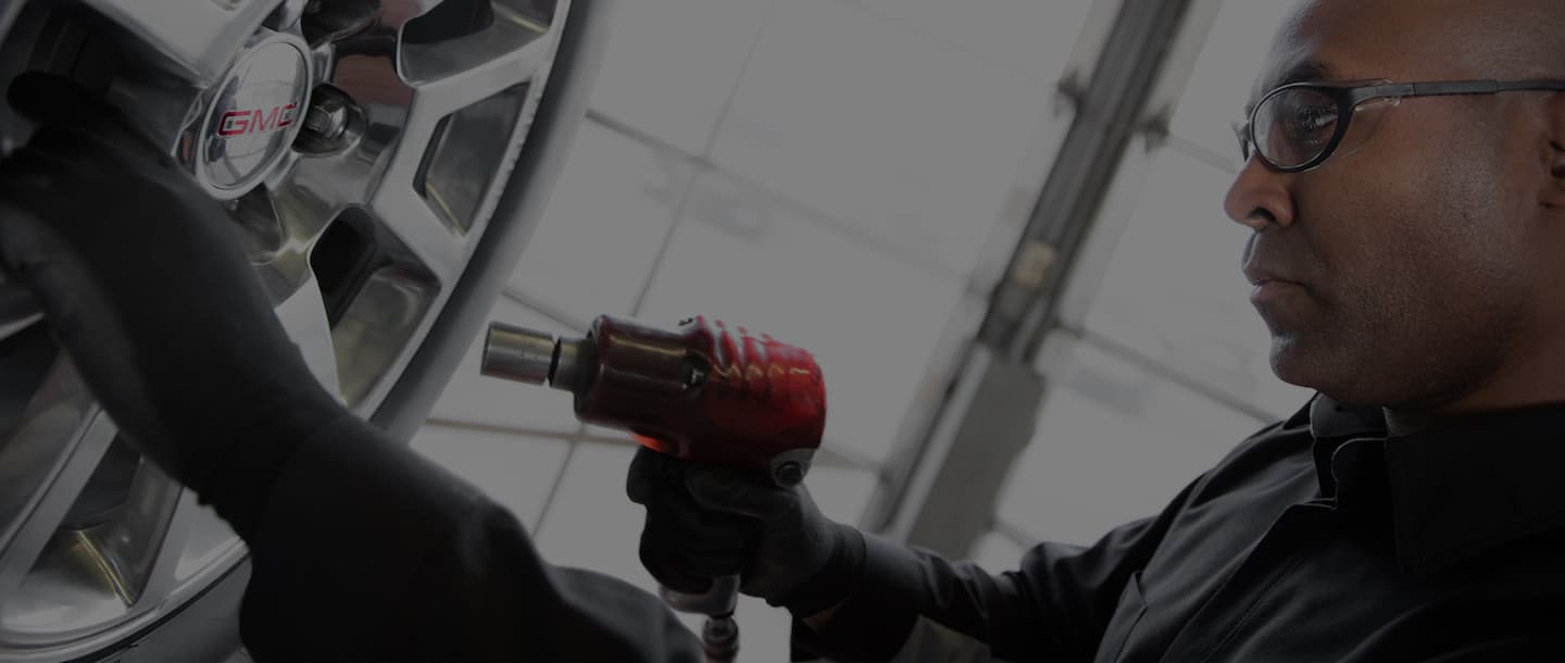 Two people looking at something and a parked van behind them.