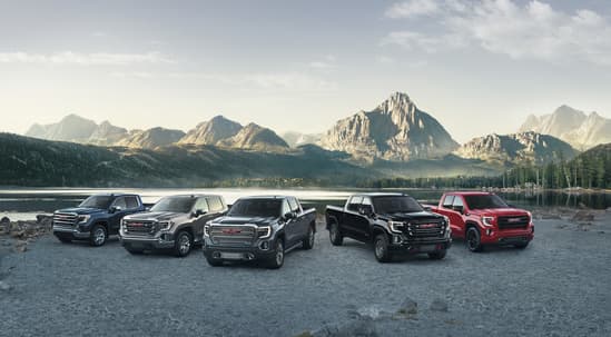 5 GMC Vehicles lined up with mountains in the background