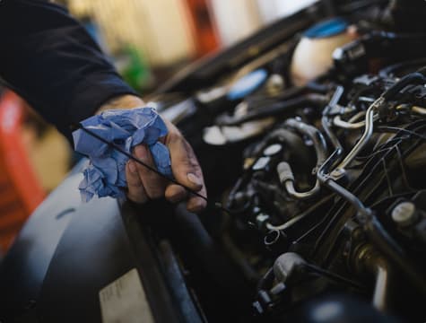 A shot of a service technician's hand, doing an oil change.