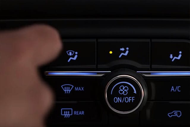 User adjusting climate control on dashboard